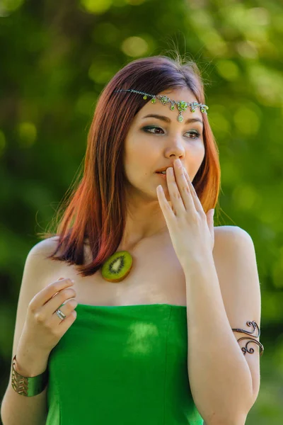 Mooie jonge Aziatische vrouw met schijfje voor kiwi op de borst — Stockfoto