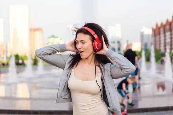 Girl listening to music streaming with headphones and making funny face.