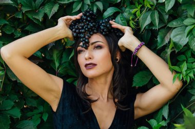 Başındaki siyah üzüm ile siyah elbiseli Genç Seksi esmer portresi.