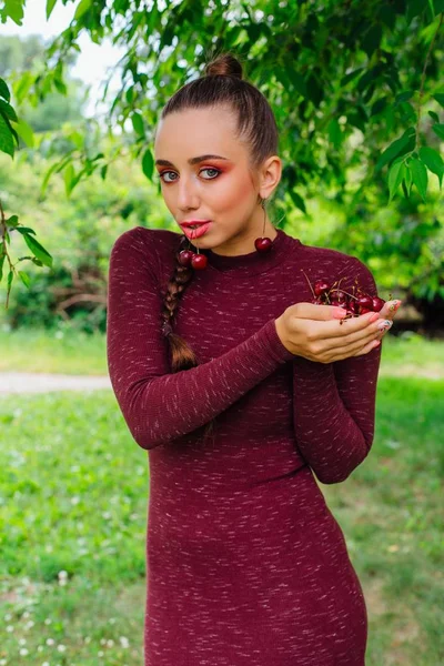 Hermosa mujer joven con trenza larga y pendientes de cereza natural . — Foto de Stock