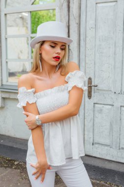 Beyaz silindir şapka ayakta eski vintage kapı ve ayna cam yanındaki seksi modern gelin.