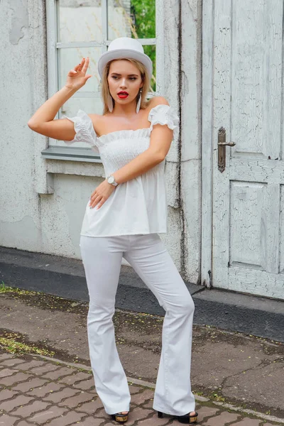 Eski beyaz vintage kapı ve ayna pencere yanında beyaz silindir şapka durduğunu içinde seksi modern gelin.