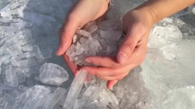 Parlak buz kristalleri kadının elinden düşer.