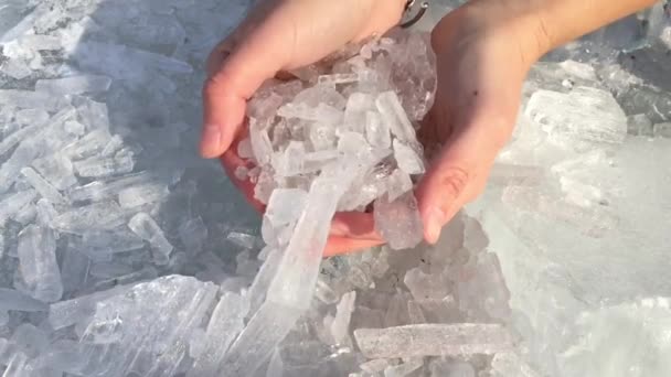 Cristales de hielo brillantes caen de las manos de las mujeres . — Vídeos de Stock