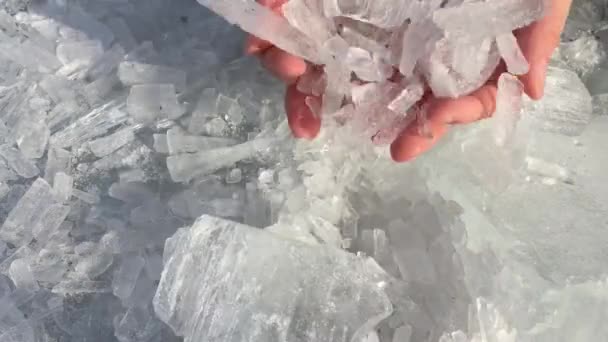 Блискучі кристали льоду падають з жіночих рук . — стокове відео