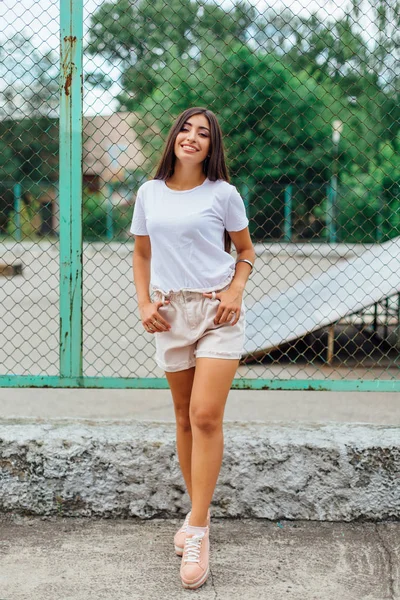 Retrato de uma menina swag de pé ao lado da cerca rabitz — Fotografia de Stock