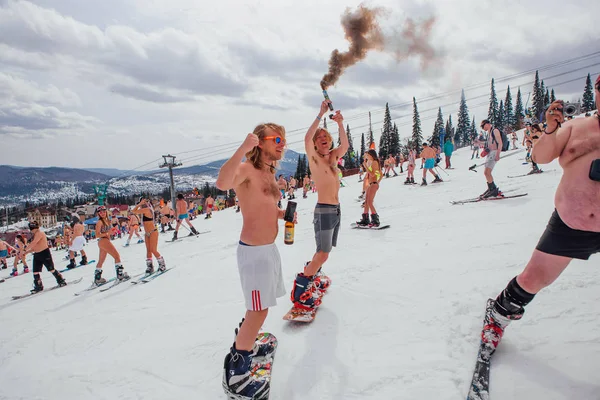 Sheregesh, 케메로보 지역, 러시아-2018 년 4 월 14 일: 비키니와 반바지 스노우 보드 및 산악 스키 슬로프에 타고 있는 사람들의 군중 — 스톡 사진