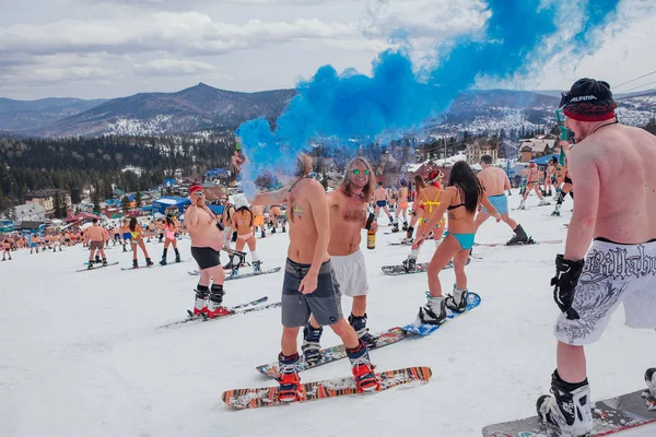 Sheregesh, région de Kemerovo, Russie - 14 avril 2018 : Une foule de personnes en bikini et en short faisant du snowboard et du ski de montagne sur la piste — Photo