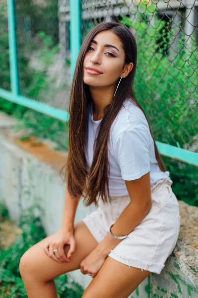 Портрет дівчини, що сидить поруч із парканом рабиці — стокове фото