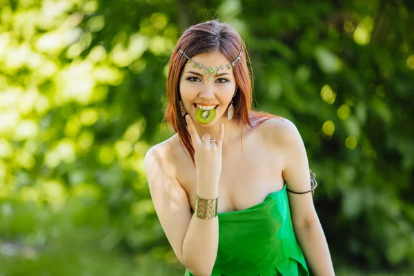 Mooie jonge Aziatische vrouw met schijfje voor kiwi in mond — Stockfoto