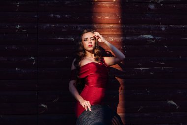 Bir tren ve ışık ışını siyah şapka ayakta uzun kırmızı bir gece elbisesi güzel genç kadın