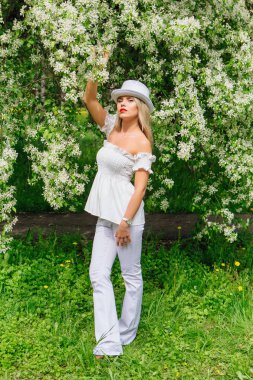 Beyaz silindir şapka enjoing bloomin elma ağacı çıtır seksi modern gelin.
