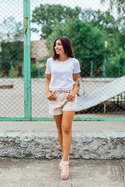 Retrato de uma menina swag de pé ao lado da cerca rabitz — Fotografia de Stock