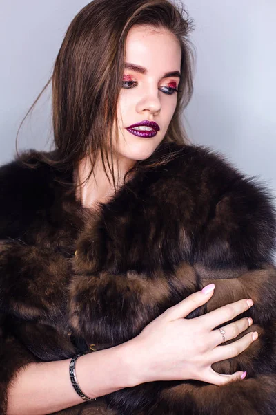 Retrato de belleza de una mujer con maquillaje colorido brillante vestida con un abrigo de piel — Foto de Stock