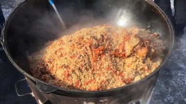 Açık hava bir kazan içinde Plov pişirme