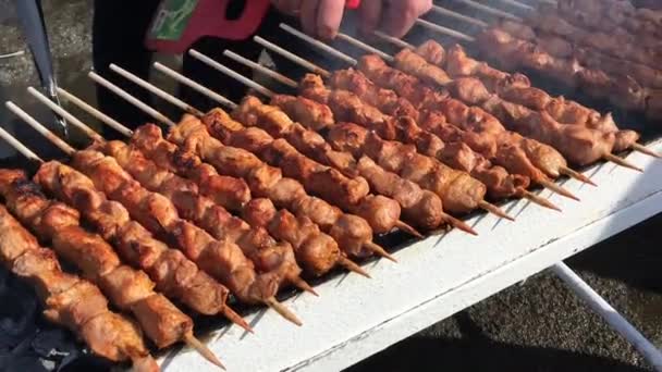 De chef-kok bereidt een barbecue. Smakelijk heerlijke gebakken stukken vlees brochettes worden gebrand op een grote grill buiten — Stockvideo