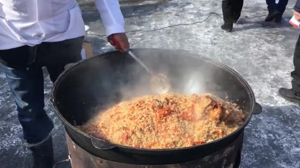 Cooking plov in a cauldron on the open air — Stock Footage Cooking plov in a cauldron on the open air Video Clip