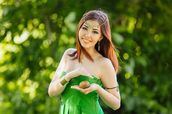 Mooie jonge Aziatische vrouw met verse kiwi — Stockfoto