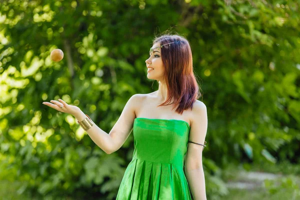 Schöne junge asiatische Frau werfen frische Kiwi — Stockfoto