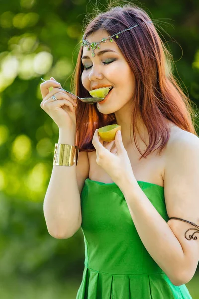 Beautiful young asian woman eating fresh kiwi — Stock Photo, Image