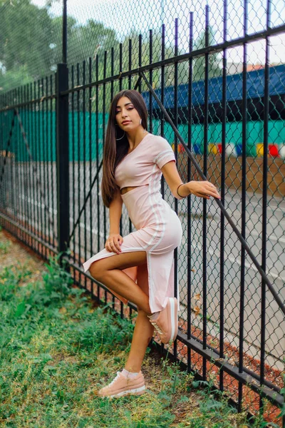 Портрет девушки, стоящей рядом с железным забором — стоковое фото