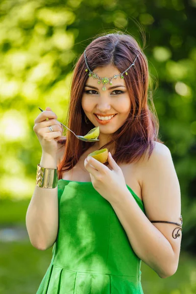 Vacker ung asiatisk kvinna äta färsk kiwi — Stockfoto