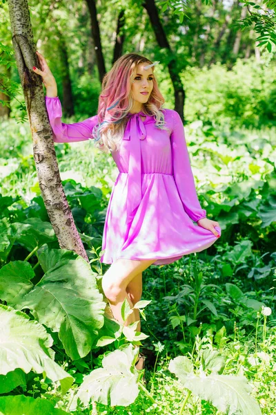 Fairy girl unicorn with pink hair in summer forest