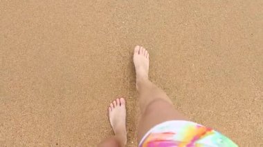 Deniz kıyısında yürüyen çıplak kadın ayaklar