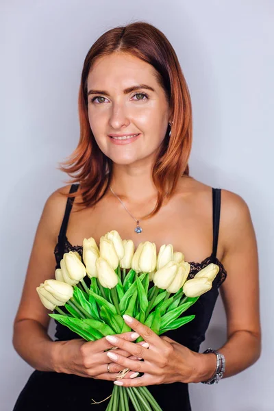 Mujer joven sosteniendo ramo de tulipanes amarillos en las manos —  Fotos de Stock