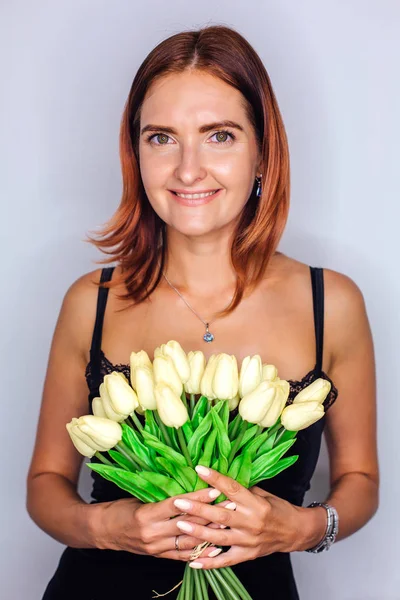 Mladá žena držící v ruce kytici žlutých tulipánů — Stock fotografie