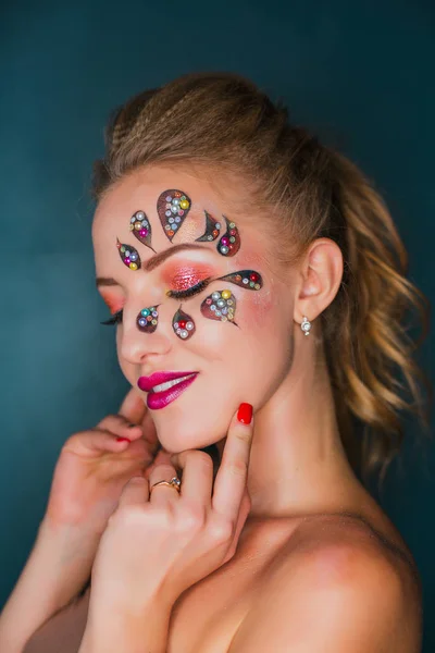 Bella giovane donna con arte volto fiore. Trucco primaverile. Creativo donna vacanza make-up con scintille e cristalli decorativi — Foto Stock