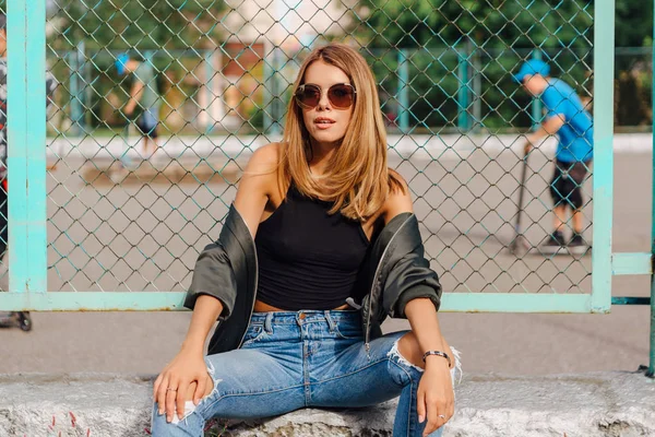 Retrato de moda de una joven de moda con gafas de sol, y chaqueta de bombardero sentado junto a Rabitz en la ciudad —  Fotos de Stock