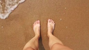 Deniz kıyısında çıplak kadın ayakları