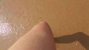 Deniz kıyısında yürüyen çıplak kadın ayaklar