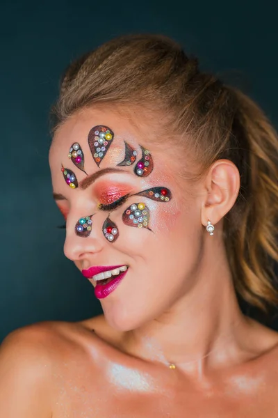 Schöne junge Frau mit Blumen-Gesicht-Kunst. Frühling Make-up. Kreatives Frauen-Urlaub-Make-up mit Perlen und dekorativen Kristallen — Stockfoto