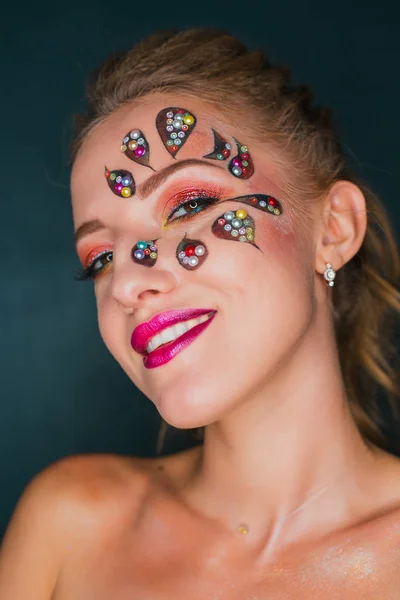 Mulher bonita com arte de rosto de flor. Maquiagem Primavera. Maquiagem de férias de mulher criativa com brilhos e cristais decorativos — Fotografia de Stock