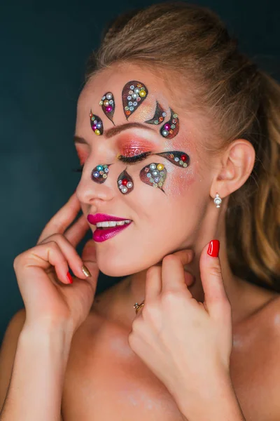 Mulher bonita com arte de rosto de flor. Maquiagem Primavera. Maquiagem de férias de mulher criativa com brilhos e cristais decorativos — Fotografia de Stock