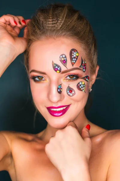 Mulher bonita com arte de rosto de flor. Maquiagem Primavera. Maquiagem de férias de mulher criativa com brilhos e cristais decorativos — Fotografia de Stock