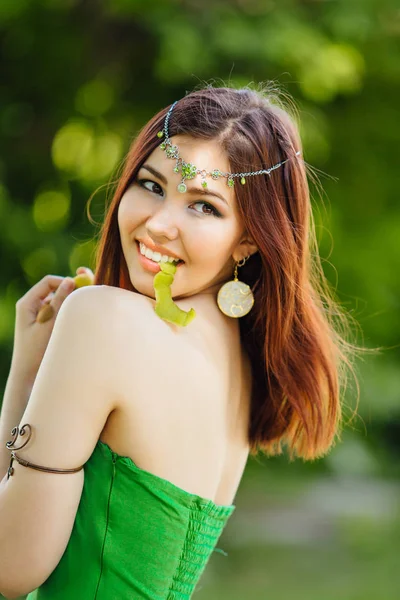 歯の新鮮なキウイの皮をむくと美しい若いアジア女性 — ストック写真