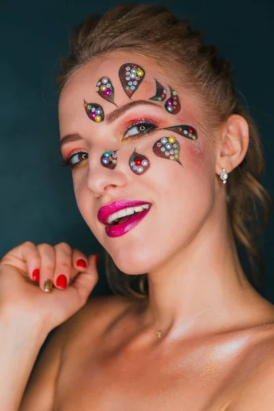 Mulher bonita com arte de rosto de flor. Maquiagem Primavera. Maquiagem de férias de mulher criativa com brilhos e cristais decorativos — Fotografia de Stock