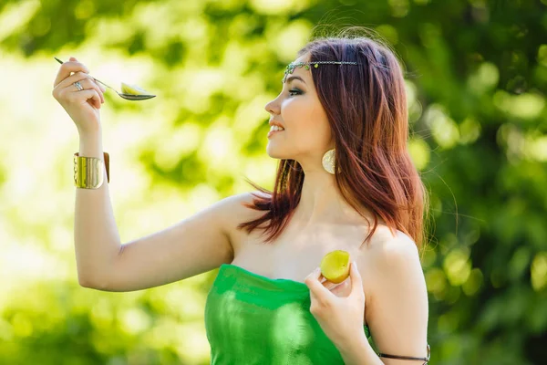 Beautiful young asian woman eating fresh kiwi — Stock Photo, Image