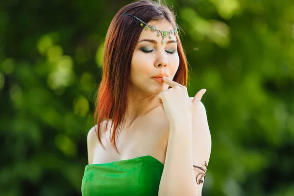 Hermosa joven asiática comiendo kiwi fresco, sosteniendo el pulgar cerca de los labios —  Fotos de Stock