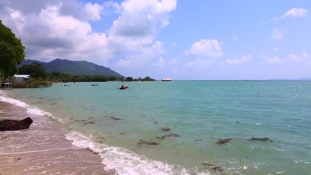 Vagues sur la plage et bateaux de pêche dans la mer 