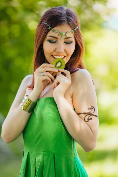 Vacker ung asiatisk kvinna bita skiva kiwi — Stockfoto