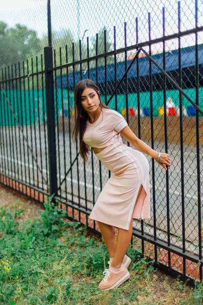 Портрет девушки, стоящей рядом с железным забором — стоковое фото