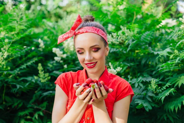 Schöne junge Pin-up-Mädchen mit hellem Make-up und frische natürliche Erdbeere. — Stockfoto