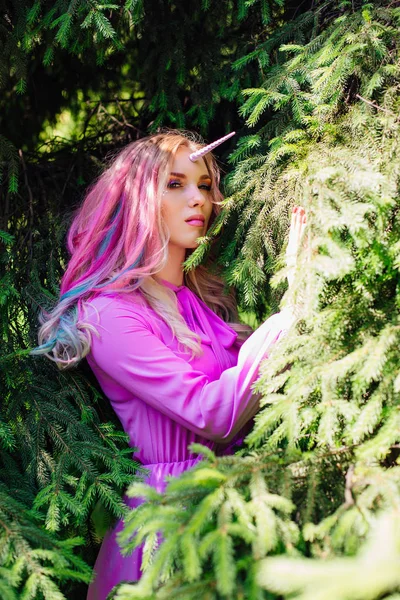 Fairy girl unicorn with pink hair in summer forest