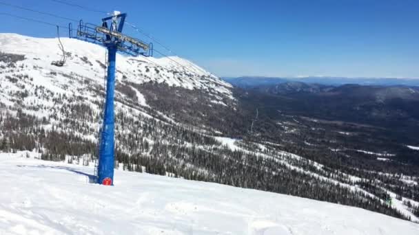 Zvedací stanice lyžařských židlí na vrcholku hory za slunečného zimního dne — Stock video