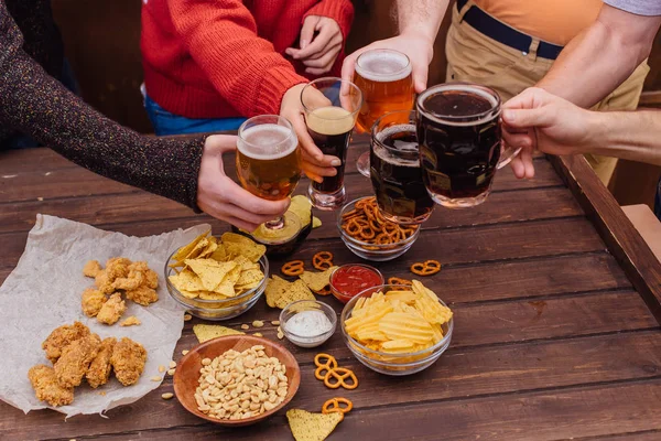 Birlikte içme bira bardakları tutan arkadaşların elleri — Stok fotoğraf