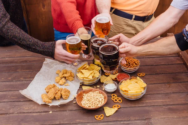 Birlikte içme bira bardakları tutan arkadaşların elleri — Stok fotoğraf
